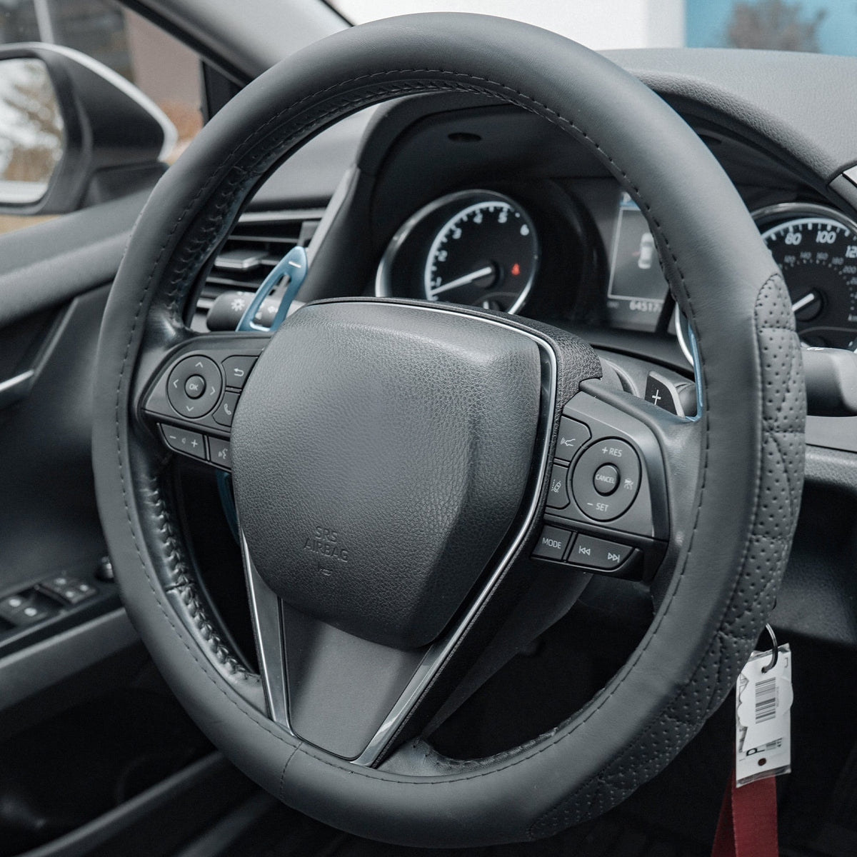 Black steering wheel cover shown from the front and side